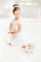 The little balerina in white tutu in class at the ballet school © master1305