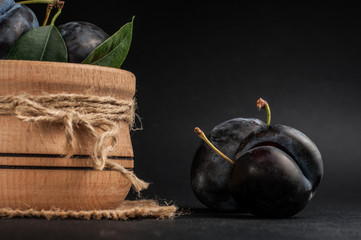 Garden plums in bowl on stone table. View with copy space