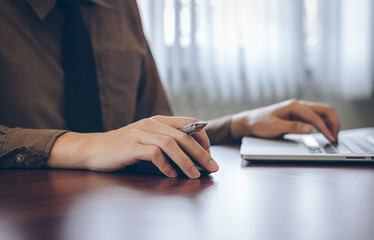 Close up businessman using laptop working in office.