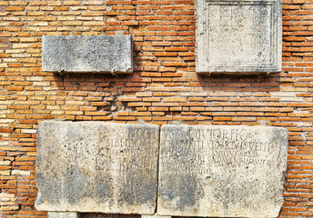 Archaeological excavations in Ostia Antica: Roman wall with marbles engraved with Latin letters.