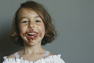 Girl shows the aftertaste from eating a chocolate dessert