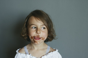 Girl shows the aftertaste from eating a chocolate dessert