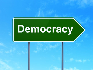 Politics concept: Democracy on road sign background