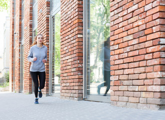 Fototapeta na wymiar Young woman jogging in city copy space