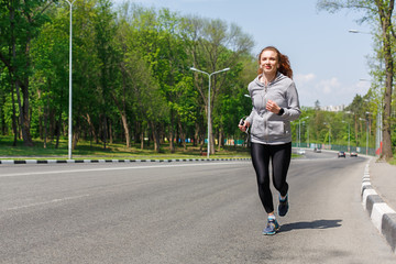 Young woman running on road, copy space