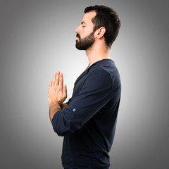 Handsome man with beard in zen position on grey background