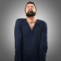 Obraz premium Handsome man with beard sending a kiss on grey background