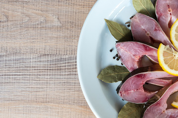 Pieces of fresh fresh carp on white plate with spices