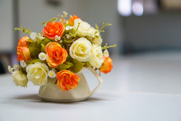 Fake or mock up bouquet flowers in a vase on the table in meeting room. copy space for text