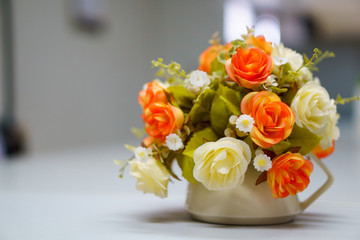 Fake or mock up bouquet flowers in a vase on the table in meeting room. copy space for text