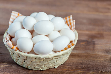 Close-up view of raw chicken eggs on wooden background