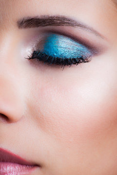 closeup of woman closeed eye with blue eye shadow