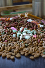 Vitamin tablets for pets on hip of dry pet food.