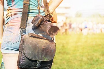 young caucasian woman with painted camera is staying on the field and looking at holi festival