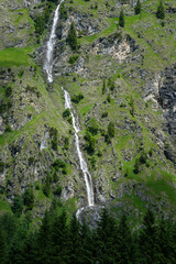 Fototapeta na wymiar Wasserfall am Berg im Allgäu vor Nadelbäumen