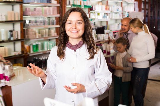 Smiling woman pharmacist helping customers