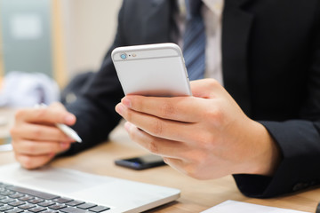 close up businessman using smartphone for checking email alert from company,business and technology concept