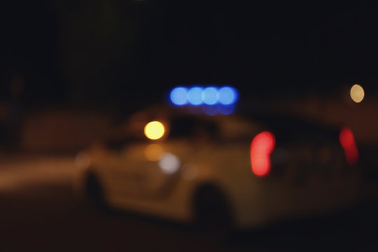 Blurred View Of Police Car On Road At Night