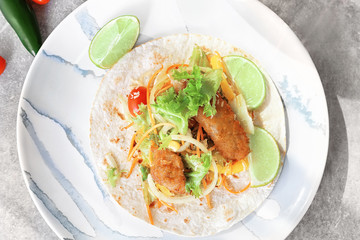 Delicious fish taco on plate on grey table