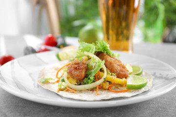 Delicious fish taco on plate on grey table