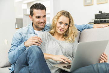 Young couple making the most of new technologies in their house