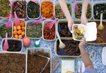 Top view of unidentified vendor and customer at the food stall in Kota Kinabalu city food market.