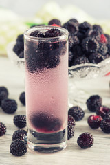 Fototapeta na wymiar Berry a cooling drink in the sweaty glass. Juice with raspberries.