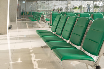 Empty airport terminal waiting area with chairs in morning time.