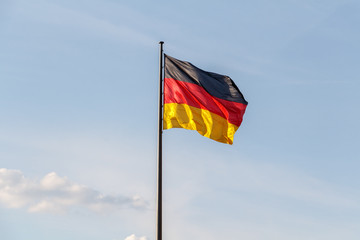 The national German flag of Germany over blue sky