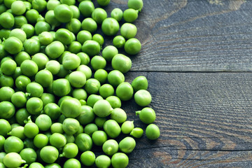 Green peas on a wooden surface, top view. Textural background