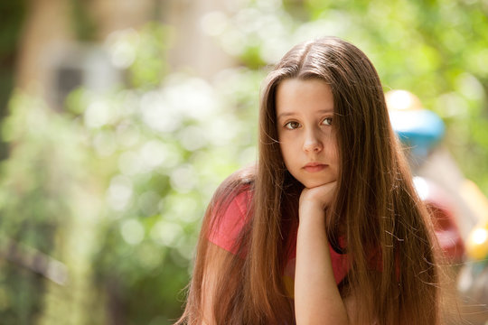 Beautiful teenage girl with a pensive and sad face expression