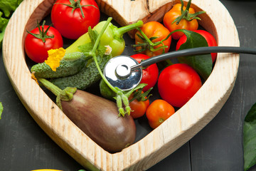 Fresh vegetables in the heart. Diet, healthy lifestyle on a black background