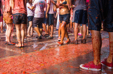 Tłum ludzi bawiących się na La Tomatina. Ujęcie nóg.  - obrazy, fototapety, plakaty