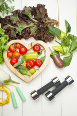 Fresh vegetables, dumbbells and heart on a white background - 168648818