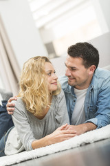 Happy young couple layed on the carpet of their living room