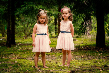 Two girls in dresses posing in the forest