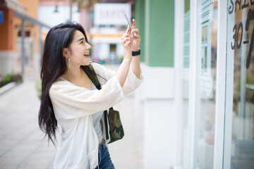 Asia woman using phone at shopping mall