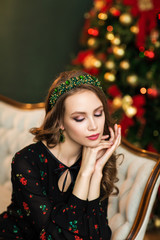 Fashion portrait of a beautiful young woman with a green jewelry