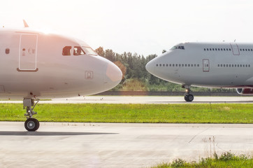 Fototapeta na wymiar Nose to nose two planes on the runway at the airport