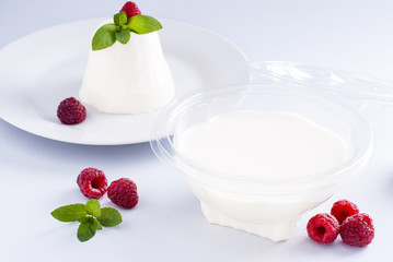 Dessert panacotta with berries in a plastic container