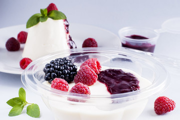 Dessert panacotta with berries in a plastic container