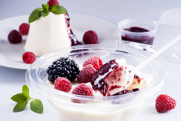 Dessert panacotta with berries in a plastic container