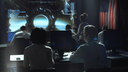 Back view of people working and managing flight in mission control center. - obrazy, fototapety, plakaty