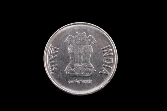 An extreme close up of an Indian two rupee coin on a solid black background
