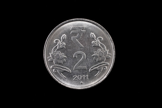 An extreme close up of an Indian two rupee coin on a solid black background