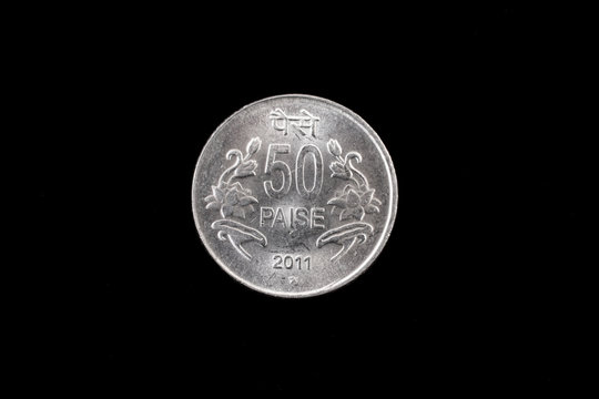 An extreme close up of an Indian fifty paise coin on a solid black background