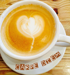 Inspirational Quote:  Carpe Diem:  Seize the Day with coffee cup and saucer filled wth latte and froth in the shape of a heart