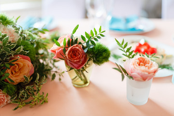 Rose Bud in a small vase and table set for event party or wedding. The flowers decoration on the wedding table