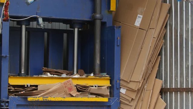 Industrial press- recycling of cardboard at industrial landfill