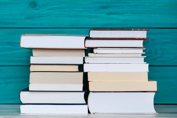 Stacks of books with wooden blue background. Back to school.